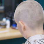A father shaves his daughter's head after she was caught bullying a classmate with cancer.